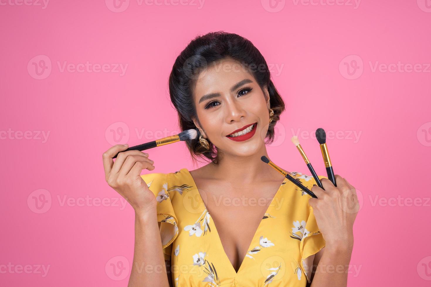 portrait d'une femme avec des pinceaux de maquillage photo