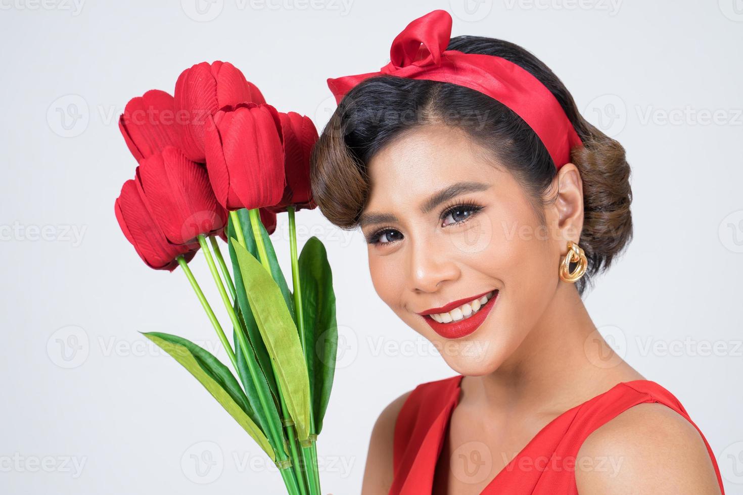 Portrait d'une belle femme avec bouquet de fleurs de tulipes rouges photo