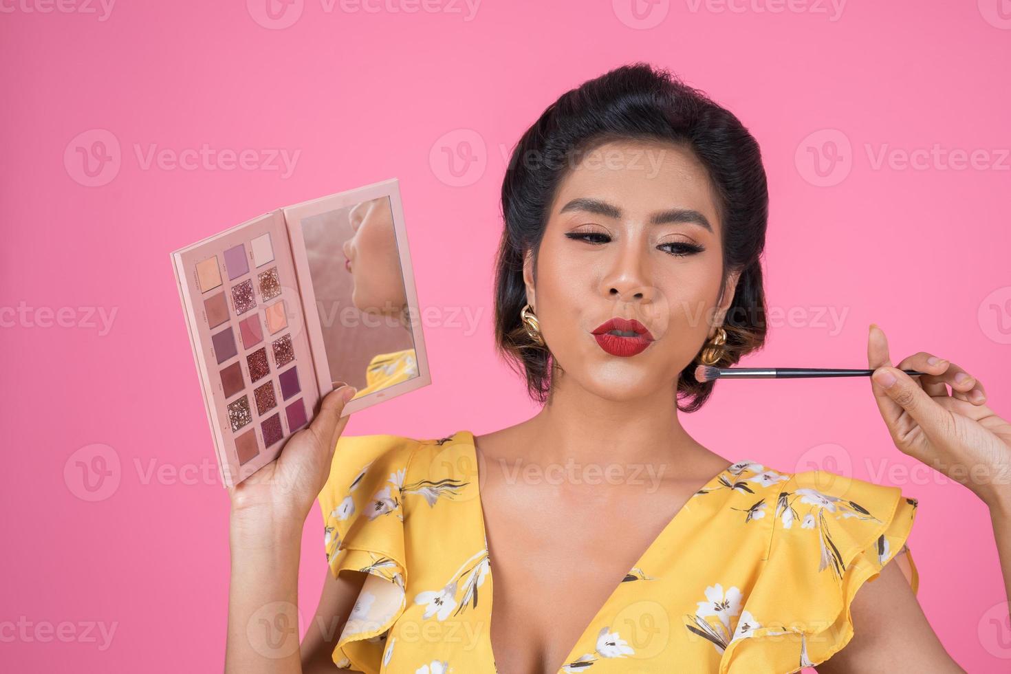 Portrait d'une femme avec maquillage et pinceau cosmétique photo