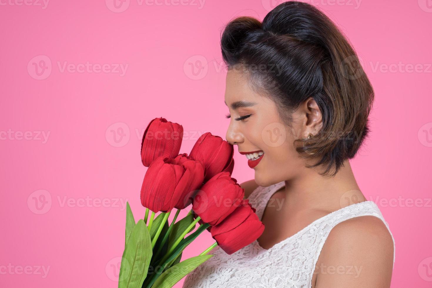 Portrait d'une belle femme avec bouquet de fleurs de tulipes rouges photo