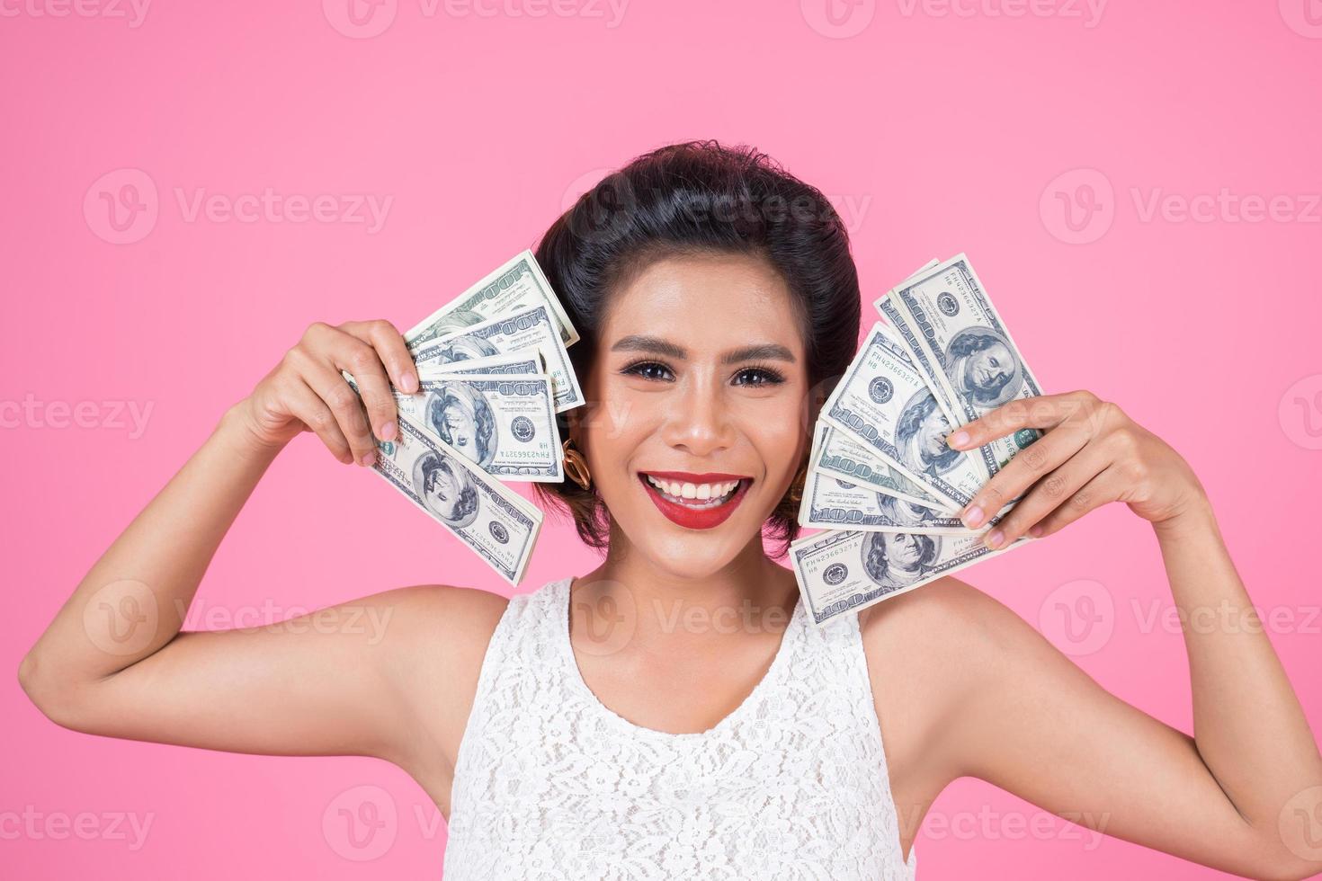 heureuse belle femme tenant des dollars photo