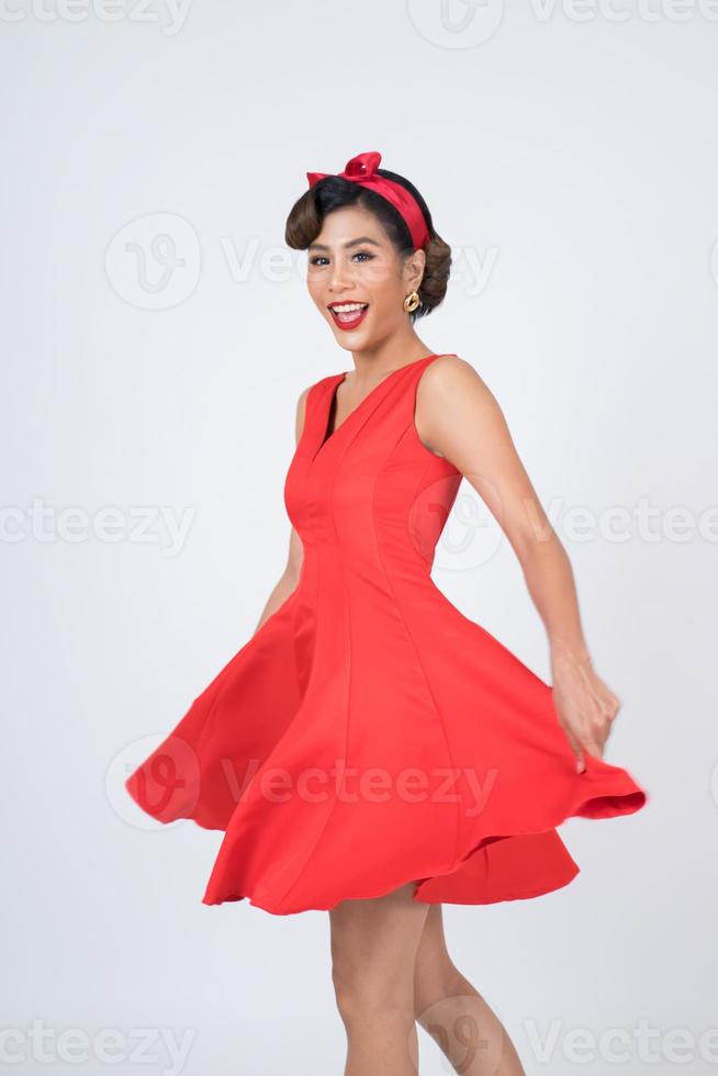belle femme vêtue d'une robe rouge en studio photo