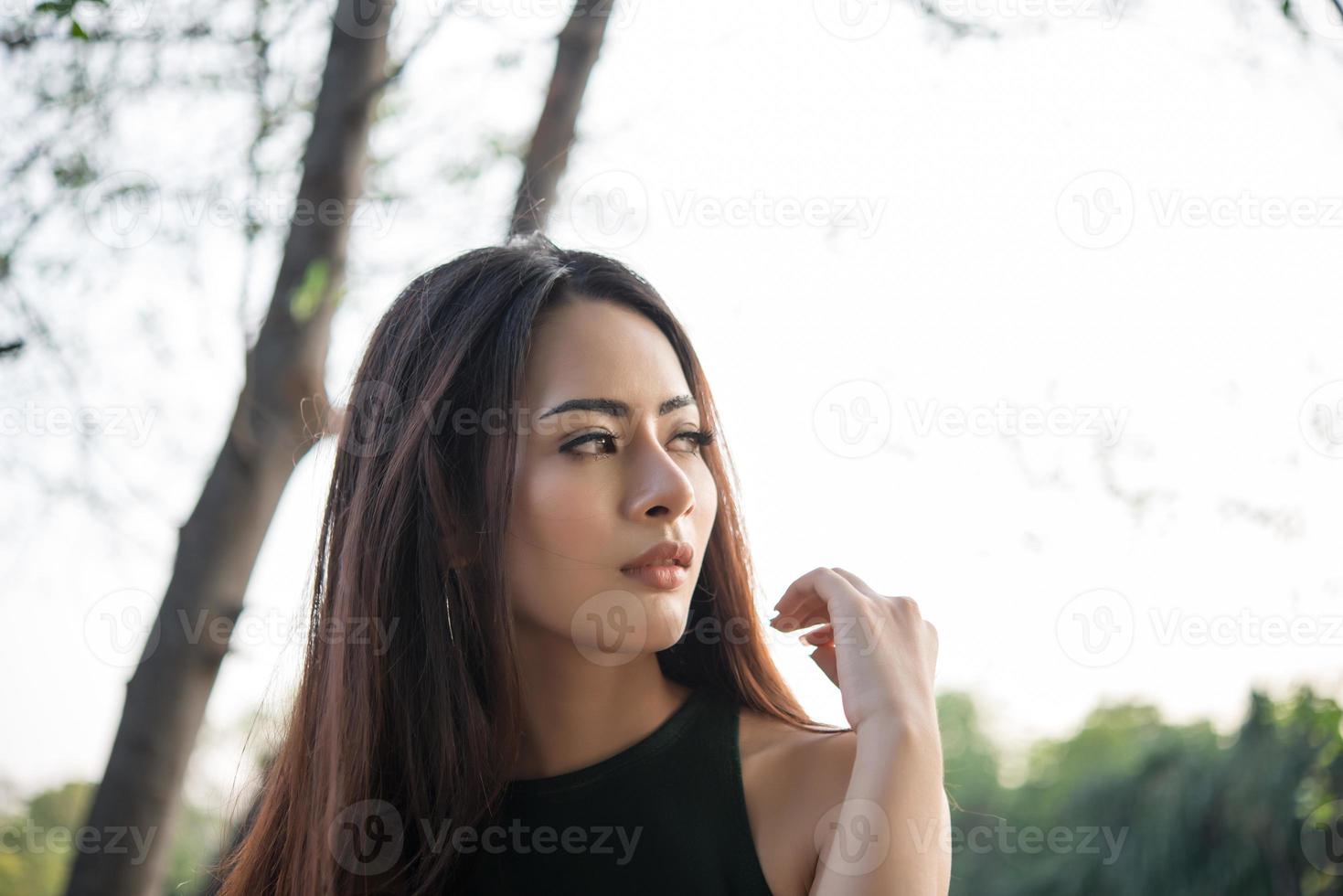 Portrait d'une jeune fille souriante se détendre dans un parc naturel en plein air photo