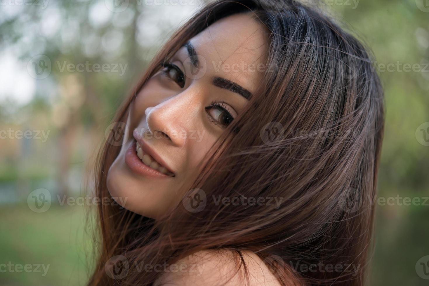 Portrait d'une jeune fille souriante se détendre dans un parc naturel en plein air photo