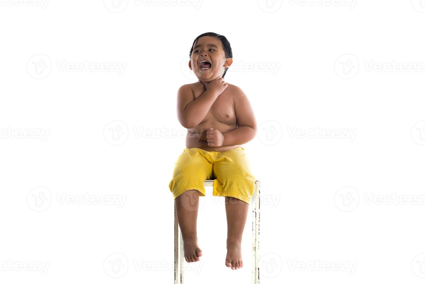 Portrait d'un petit garçon assis isolé sur fond blanc photo