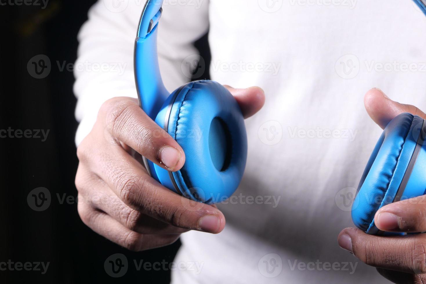 homme main tenant un casque sur fond bleu photo