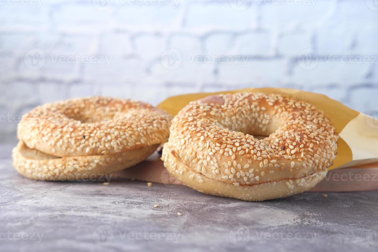 Pain bagel frais dans un papier sur la table photo