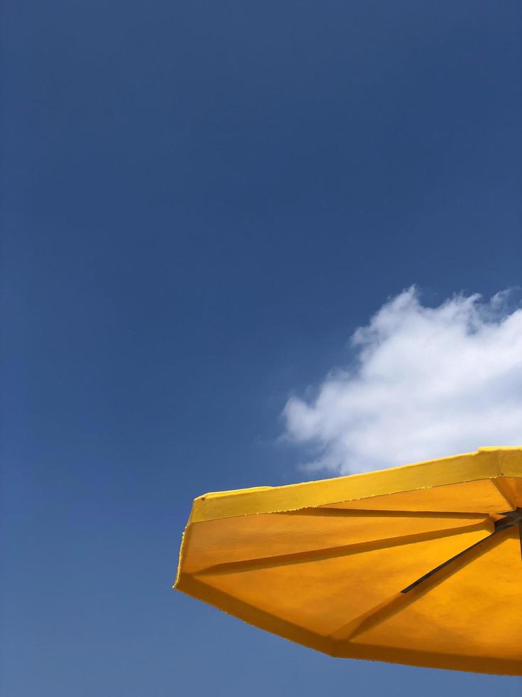 Parasol jaune avec une tache de nuages en arrière-plan photo