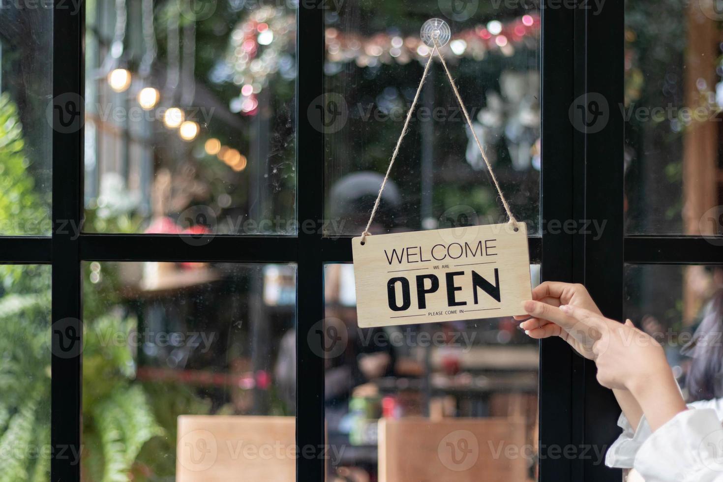 café magasin des employés sont retournement boutique ouverture signe installée sur verre de face porte donc cette les clients pouvez voir boutique ouverture signe et utilisation le un service à l'intérieur le café magasin. Commencez affaires concept. photo