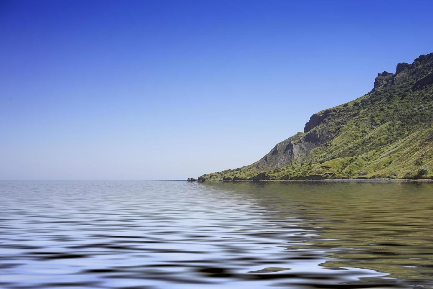 Plan d'eau à côté de la montagne avec un ciel bleu clair à Koktebel, Crimée photo