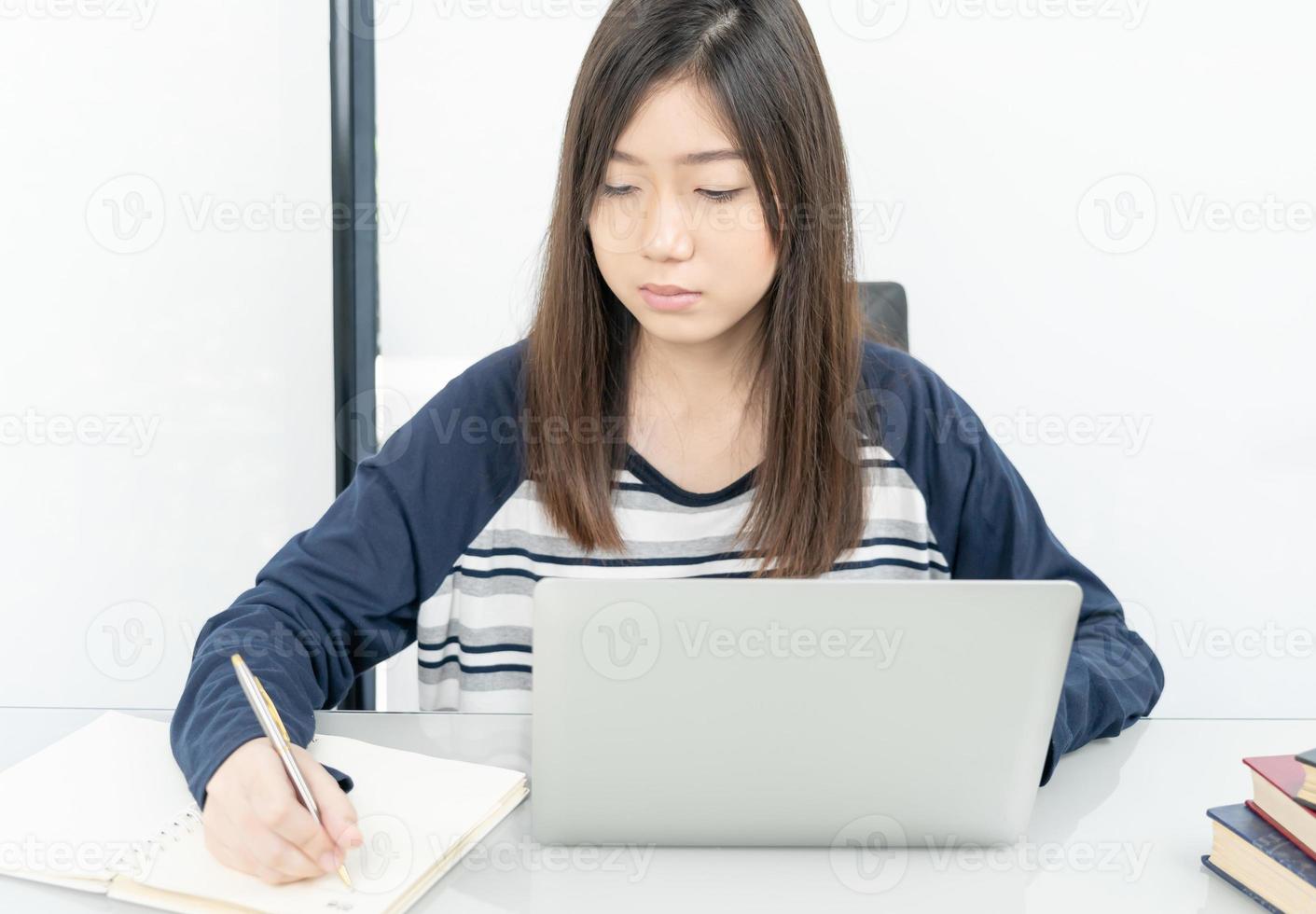 jeune étudiante assise dans le salon et apprenant en ligne photo