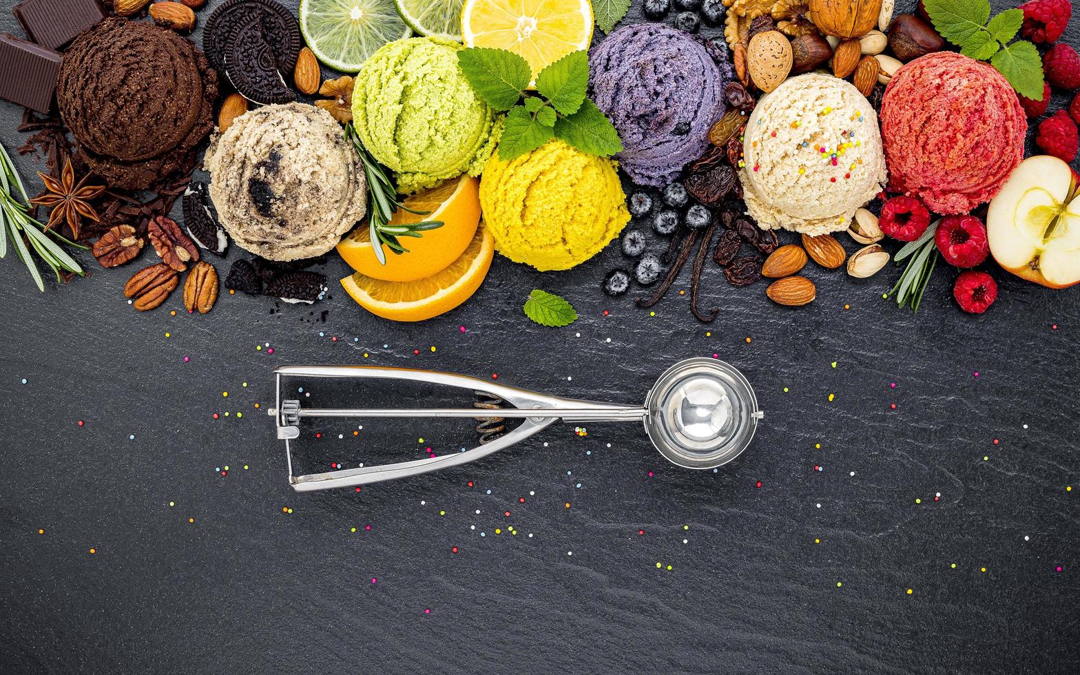 boules colorées de crème glacée avec des fruits et une cuillère à glace photo