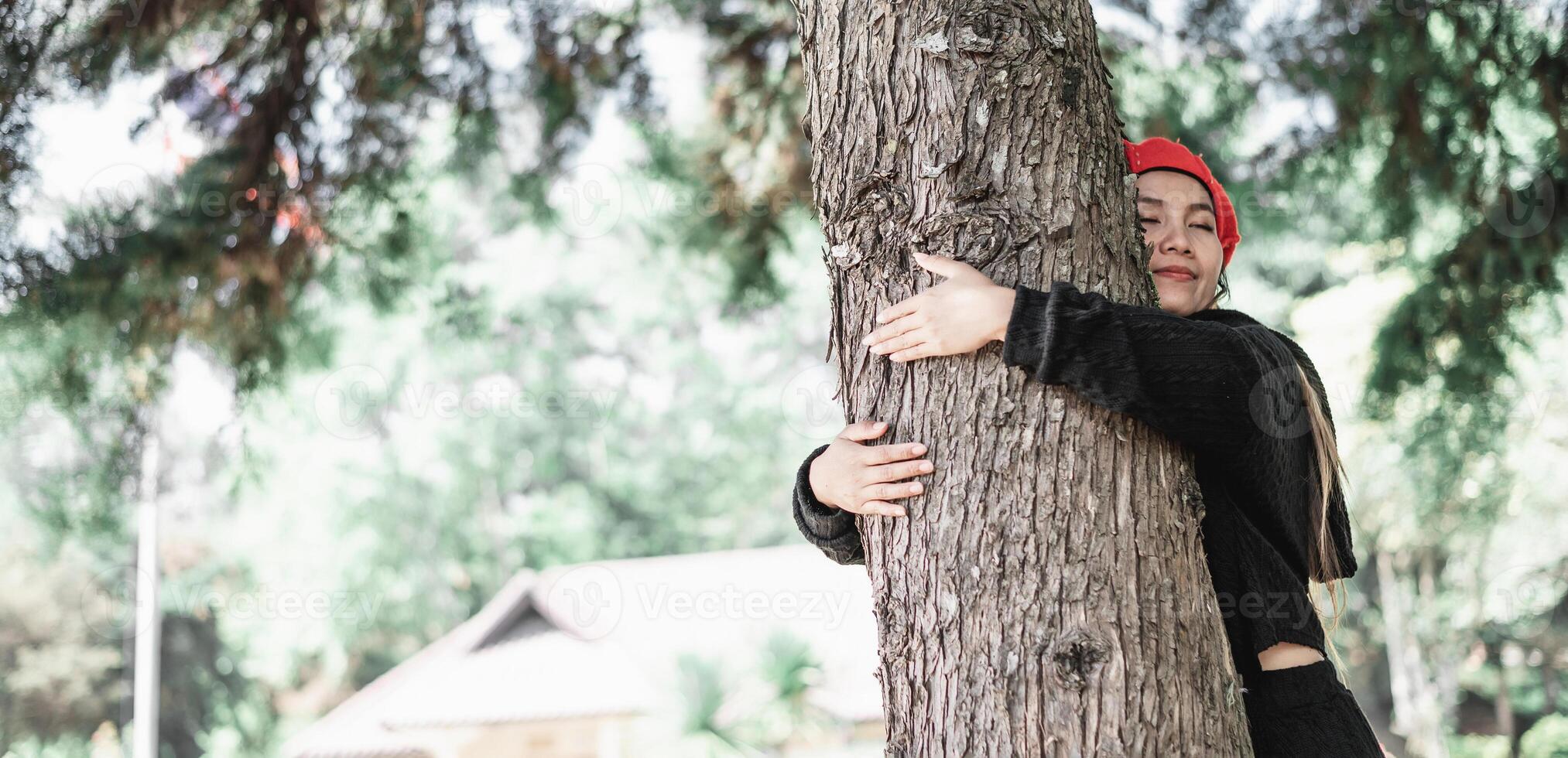 content Jeune femme étreindre une grand arbre avec une bienheureux expression avec copie espace photo