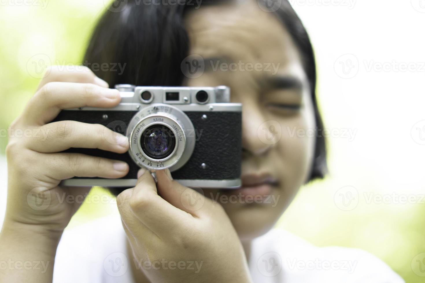 film caméra dans le mains de une fille prise une photo. vert des arbres boudoir toile de fond.femme prise Photos avec une caméra, sélectif se concentrer, doux se concentrer.