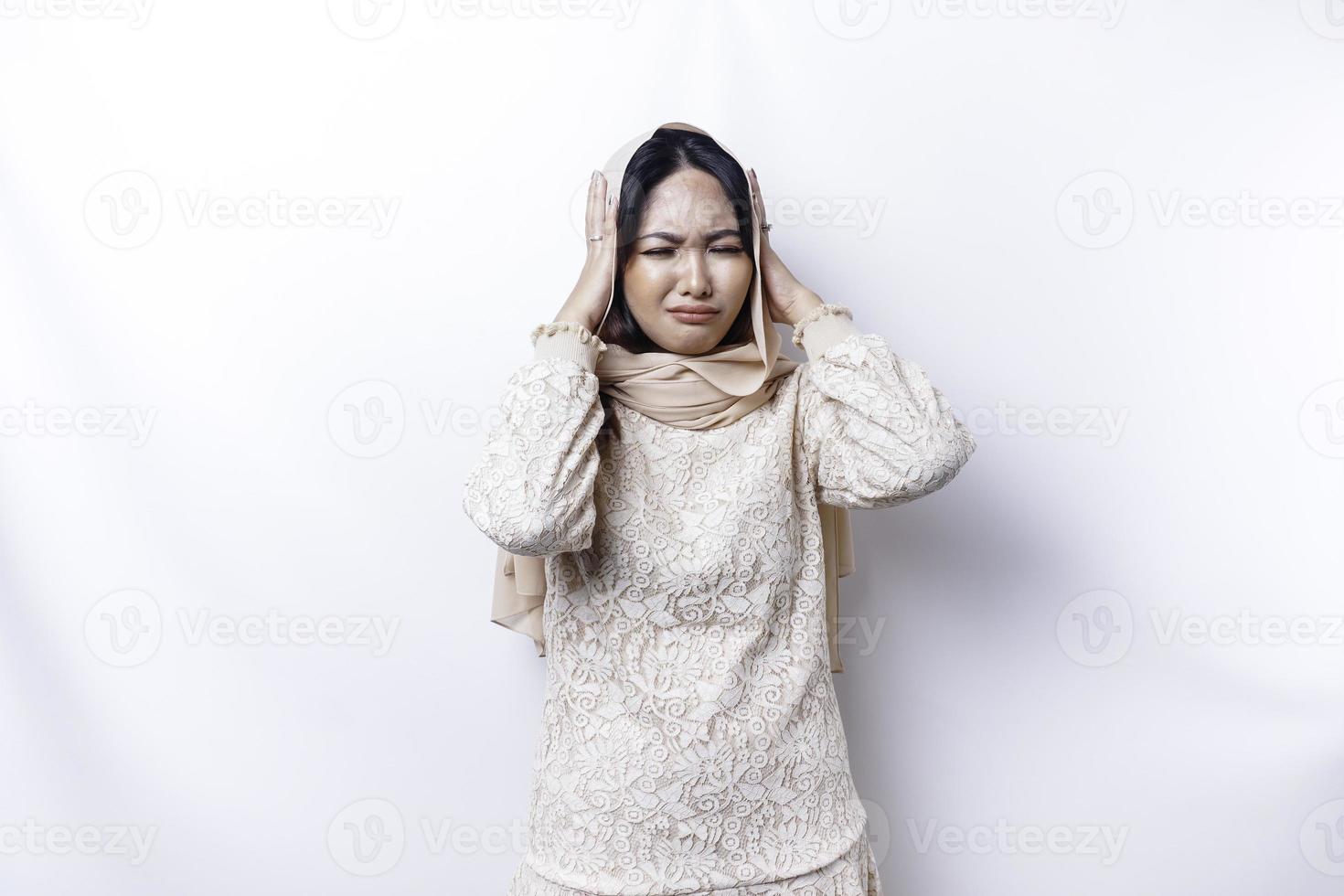 une portrait de un asiatique musulman femme portant une hijab isolé par blanc Contexte regards déprimé photo