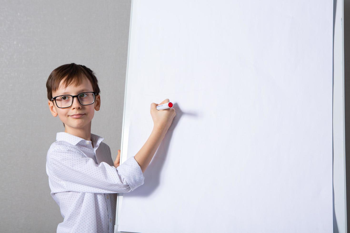 européen blanc garçon permanent près école planche pour présentation. éducation, enfance, devoirs et école concept. photo