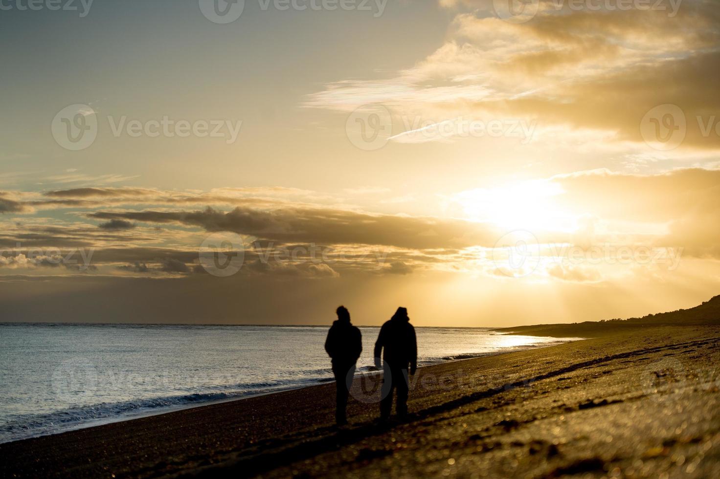 silhouette d'homme sur la plage au lever du soleil photo