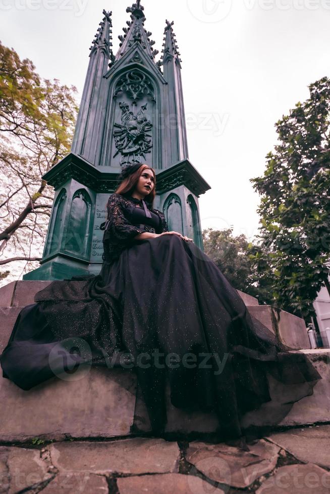 un asiatique femme habillé tout dans noir a été séance dans une cimetière avec une très effrayant expression tandis que assister le décès de sa frère photo