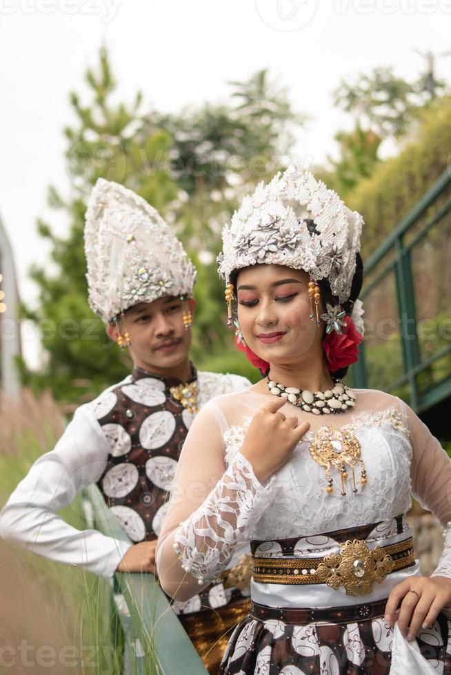 une couple dans blanc vêtements posant très intimement et intimement dans une parc photo