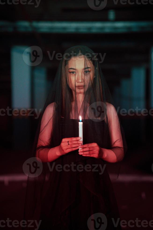 une femme adorer Satan en portant une bougie dans sa main lorsque une rituel est Aller à être tenue à une cimetière photo