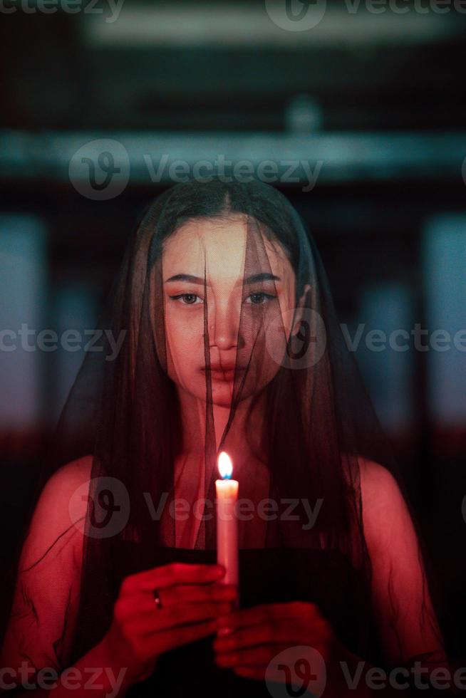 une femme adorer Satan en portant une bougie dans sa main lorsque une rituel est Aller à être tenue à une cimetière photo