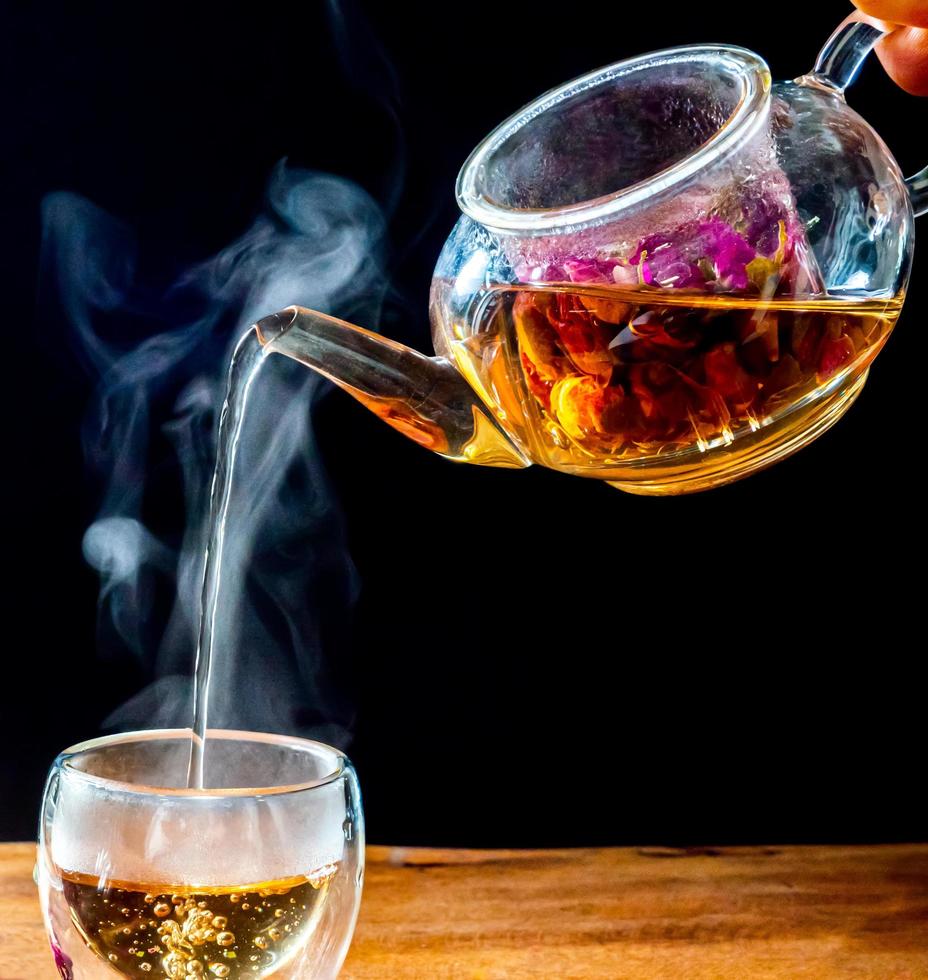 Feuilles de thé rose dans une bouilloire en verre photo
