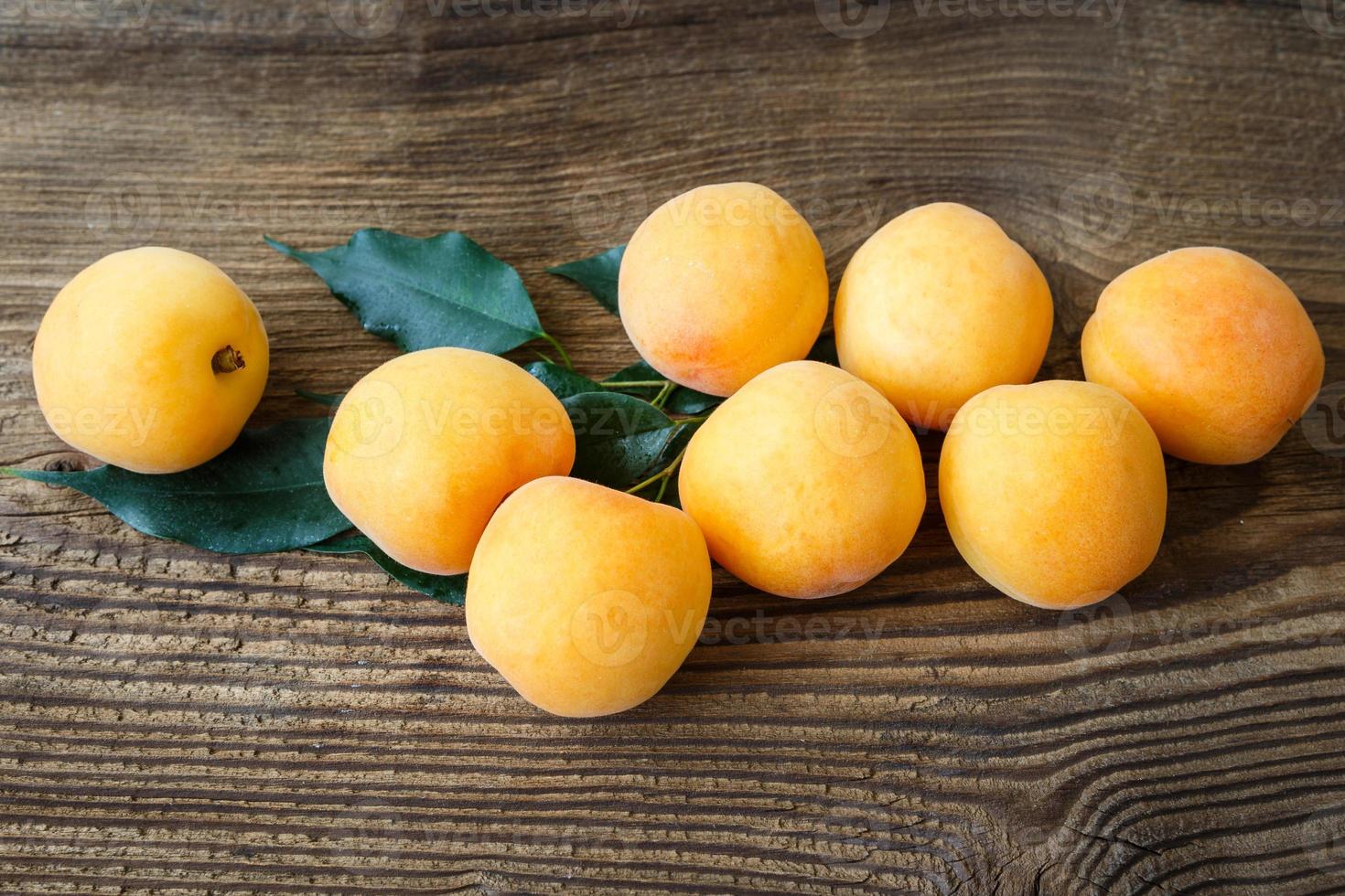 abricots avec feuilles sur le vieux en bois table photo