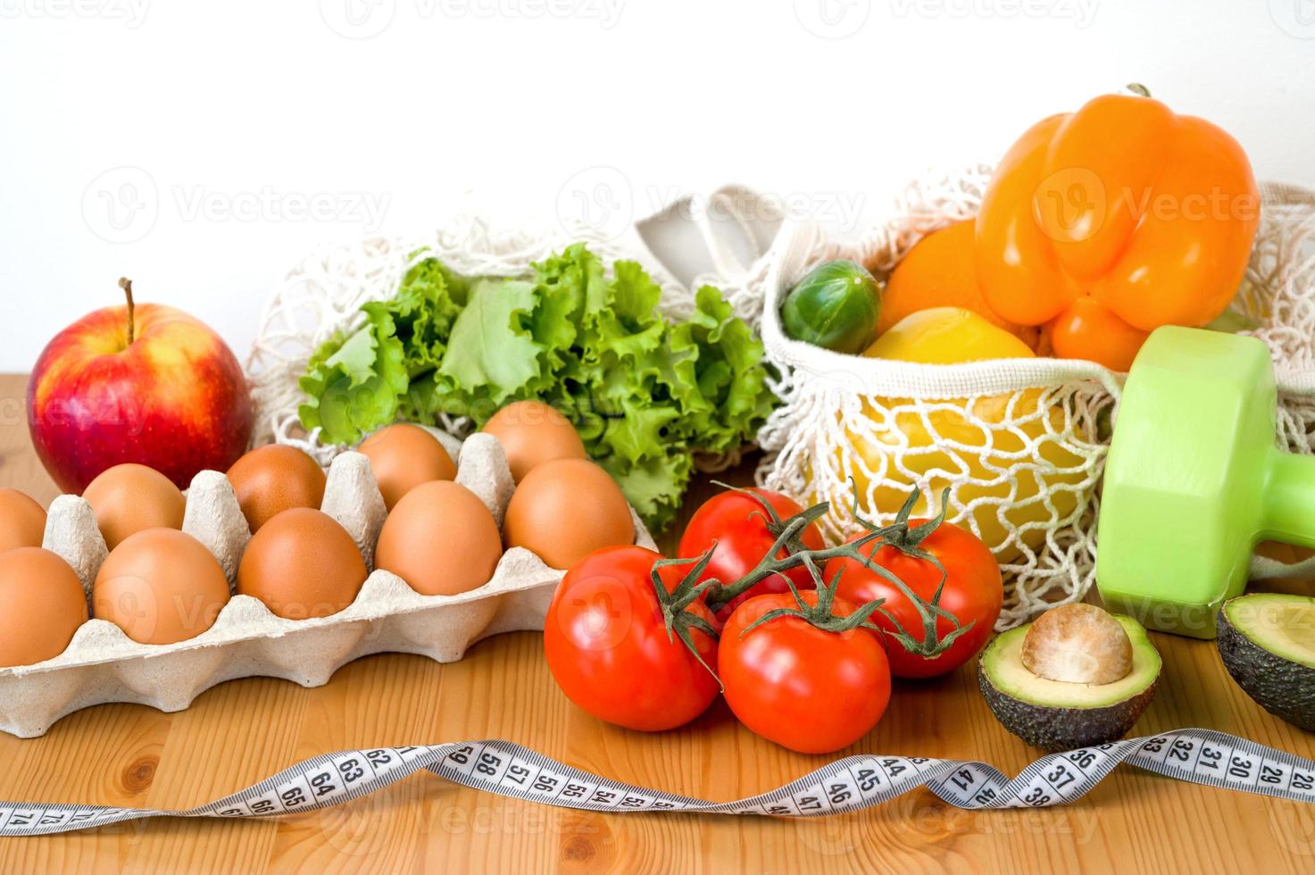 légumes et fruits près des haltères et du ruban à mesurer. concept de sport et de régime. Habitudes alimentaires saines photo