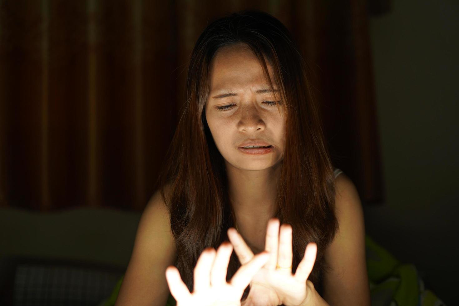 asiatique femmes souffrir de fatigue des yeux de à la recherche à des ordinateurs dans faible lumière. regarder films en ligne photo