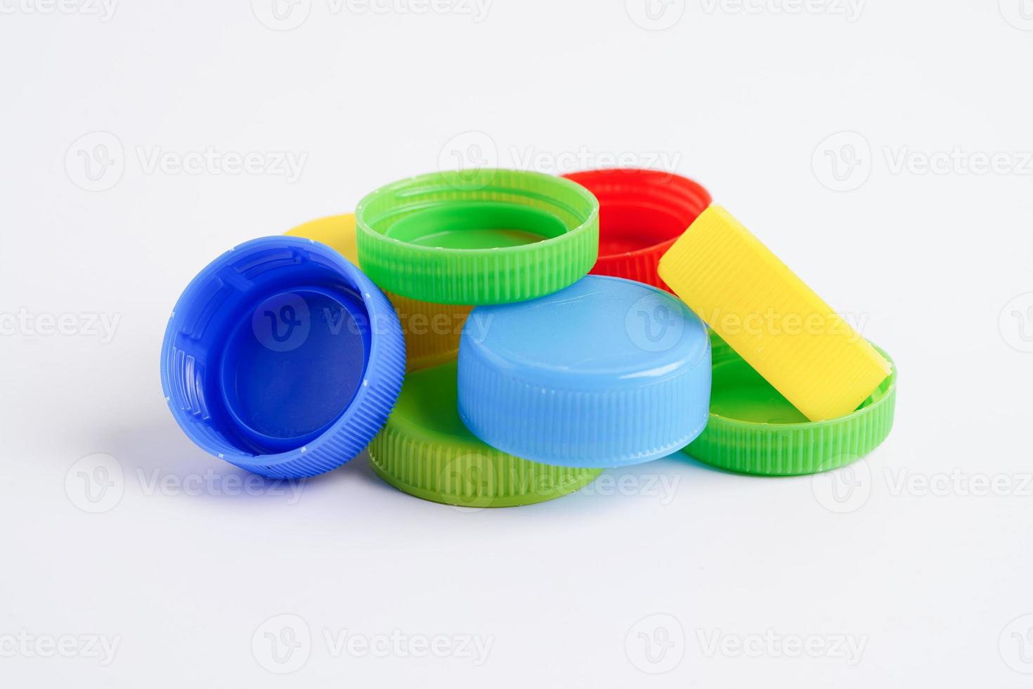 bouchons de bouteilles en plastique colorés pour recyclage sur fond blanc. photo