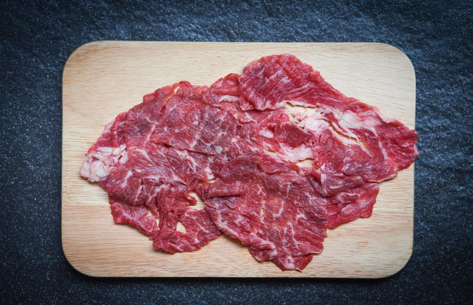 Viande du boeuf tranche sur en bois Coupe planche pour cuit ou Sukiyaki shabu shabu Japonais nourriture asiatique cuisine - Frais du boeuf brut photo