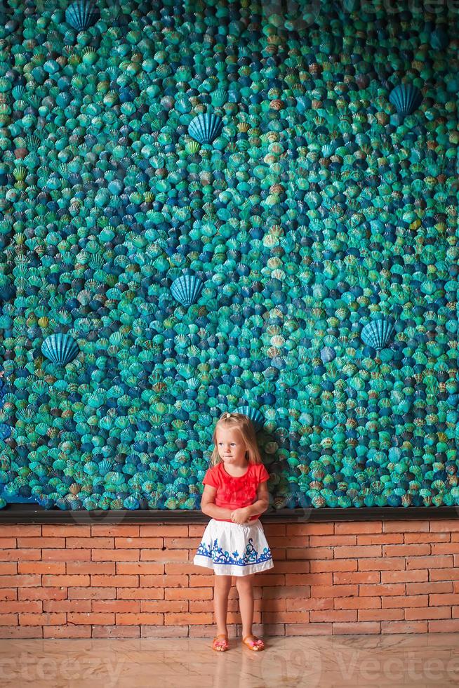 peu fille derrière une coquille mur photo