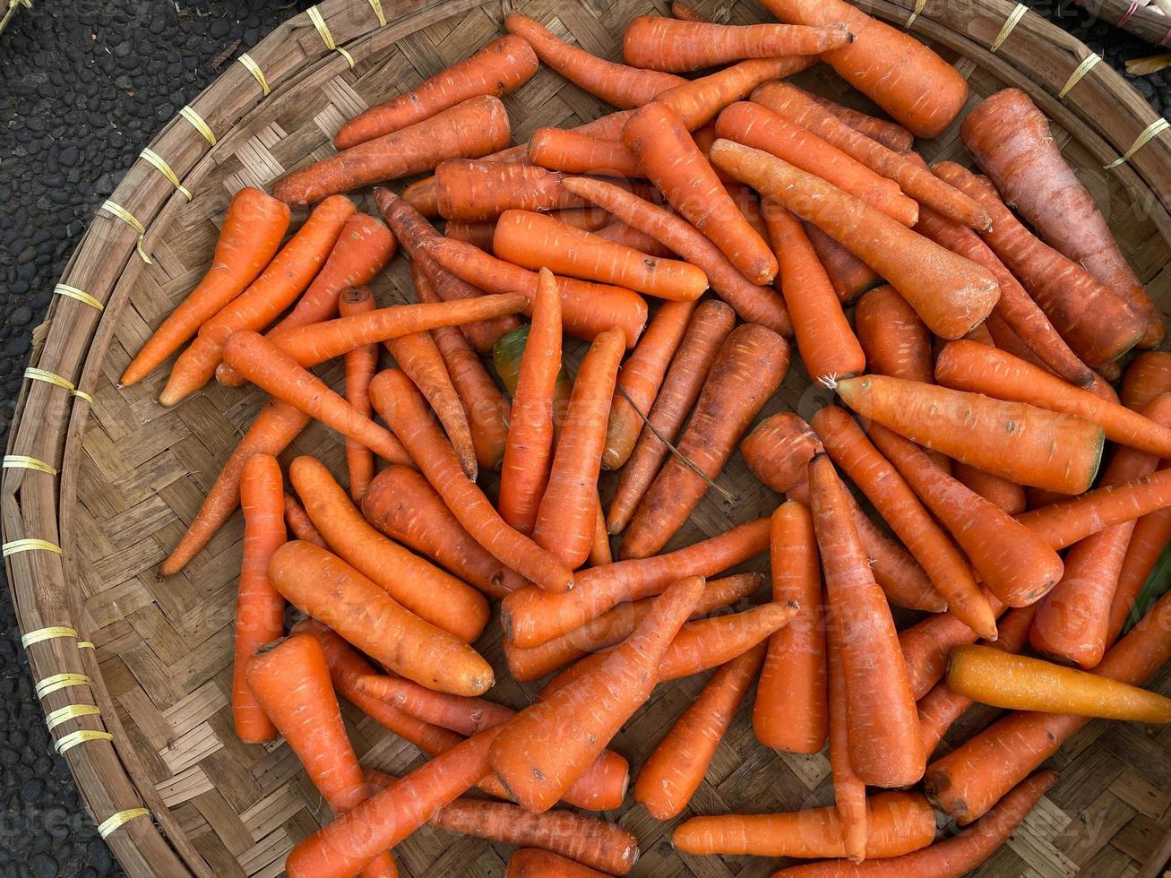 frais, biologique et imparfait carottes sur rond bambou plateau étant vendu à traditionnel marché photo