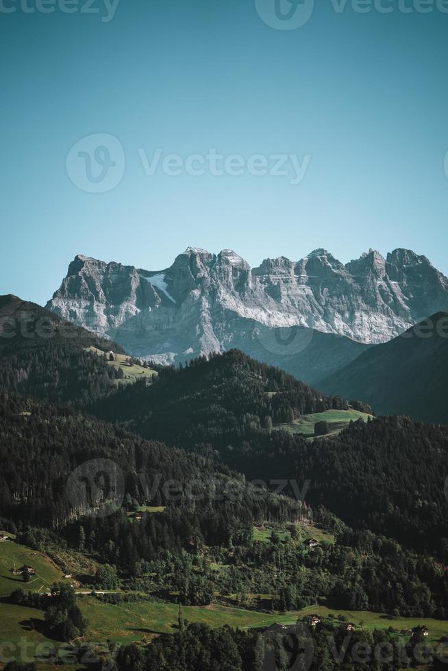 majestueux montagnes dans le Alpes couvert avec des arbres et des nuages photo