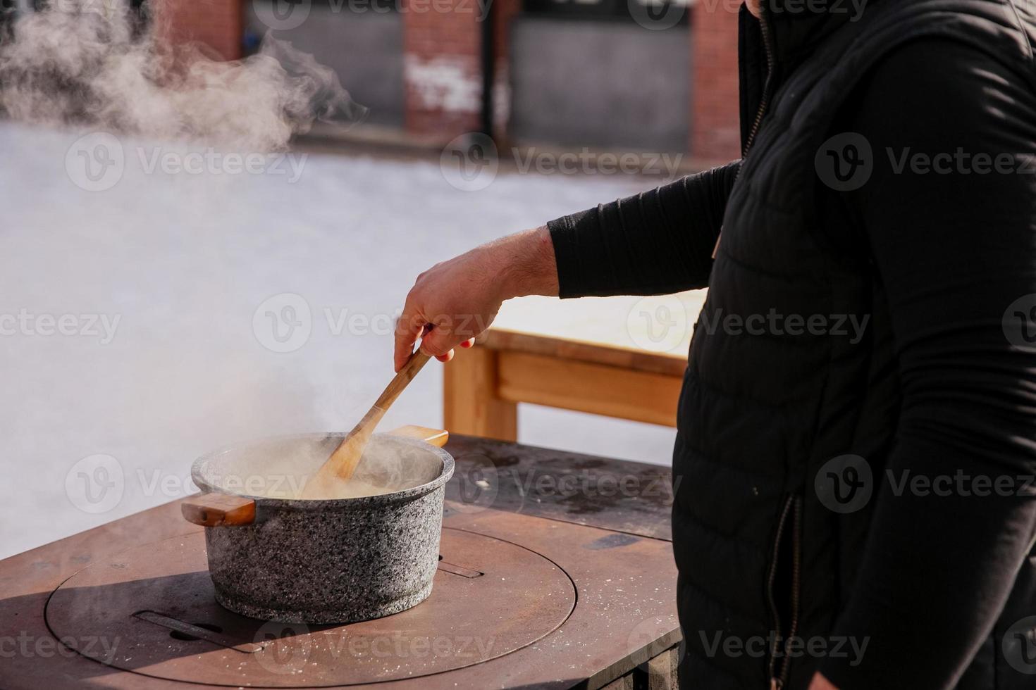 le cuisinier cuisiniers en plein air dans hiver, magnifique vapeur de une fraîchement cuit plat photo