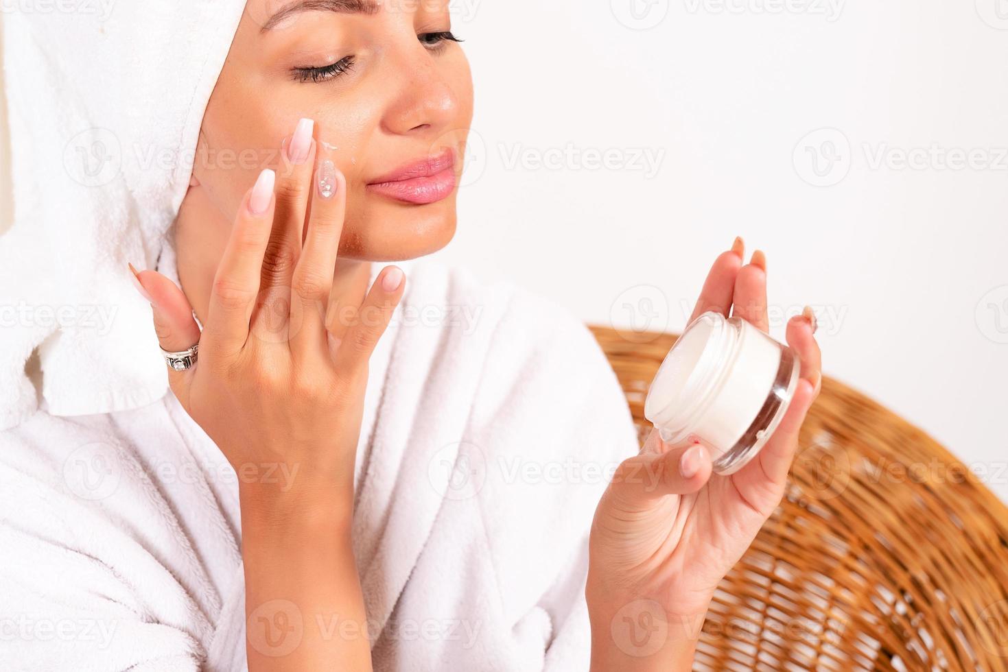 beauté, se soucier, santé, une fille dans une blanc manteau prend se soucier de se, elle frottis Quelqu'un sur sa visage photo