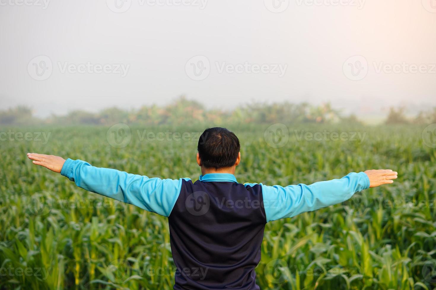 retour veiw de homme des stands Extérieur, bras tendu, ressentir gratuit, prendre plaisir la nature. faire exercer, corps élongation dans le Matin. concept, content mode de vie. bien santé, bien être. relaxation. photo