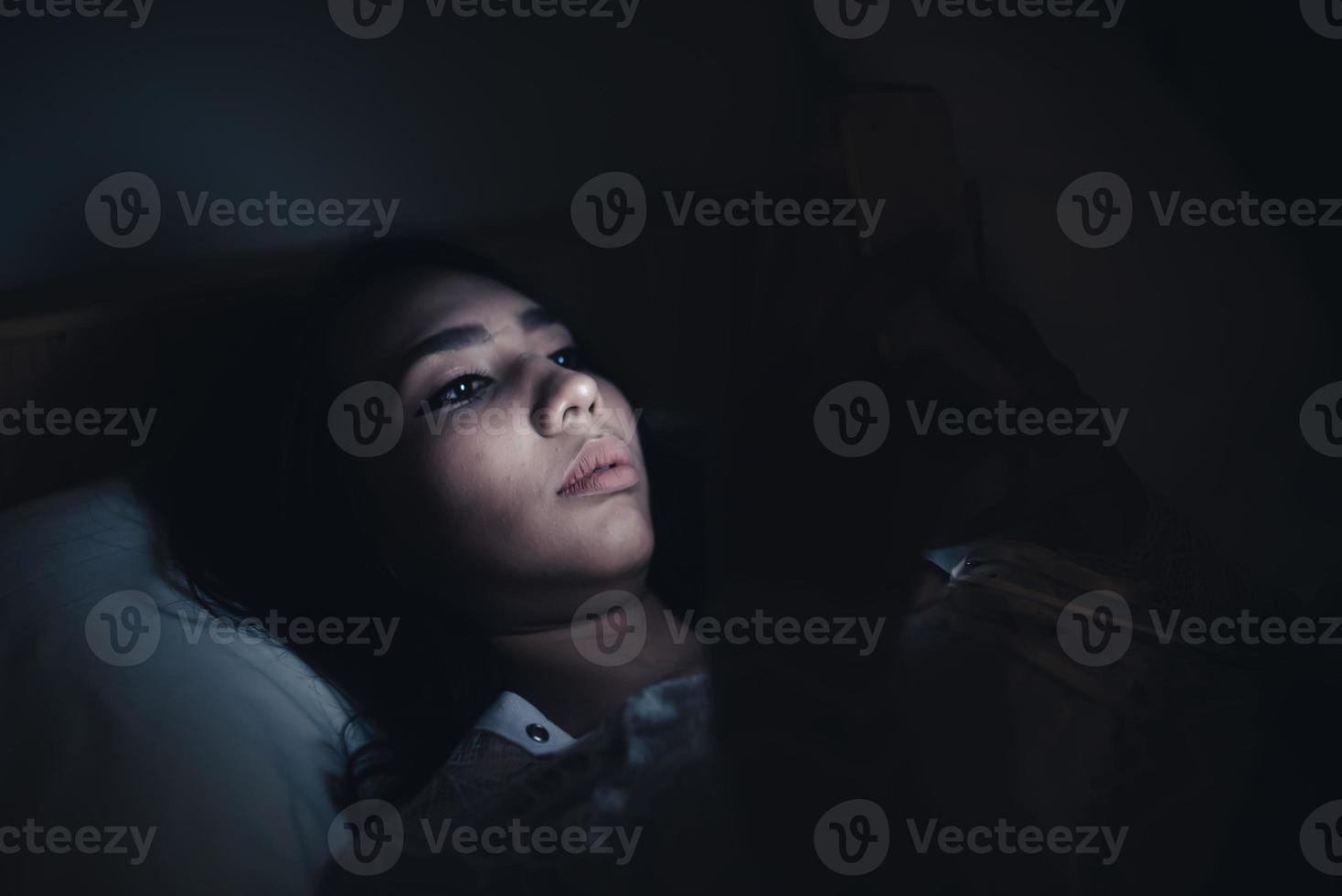 femme asiatique jouant au jeu sur smartphone dans le lit la nuit, thaïlande, toxicomane médias sociaux photo