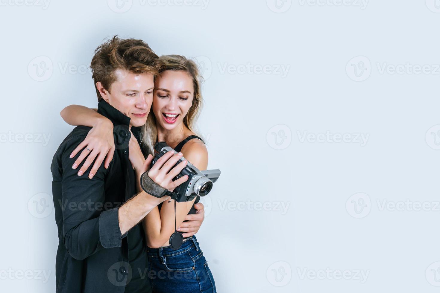 Heureux portrait de couple tenant une caméra vidéo et l'enregistrement d'une vidéo photo
