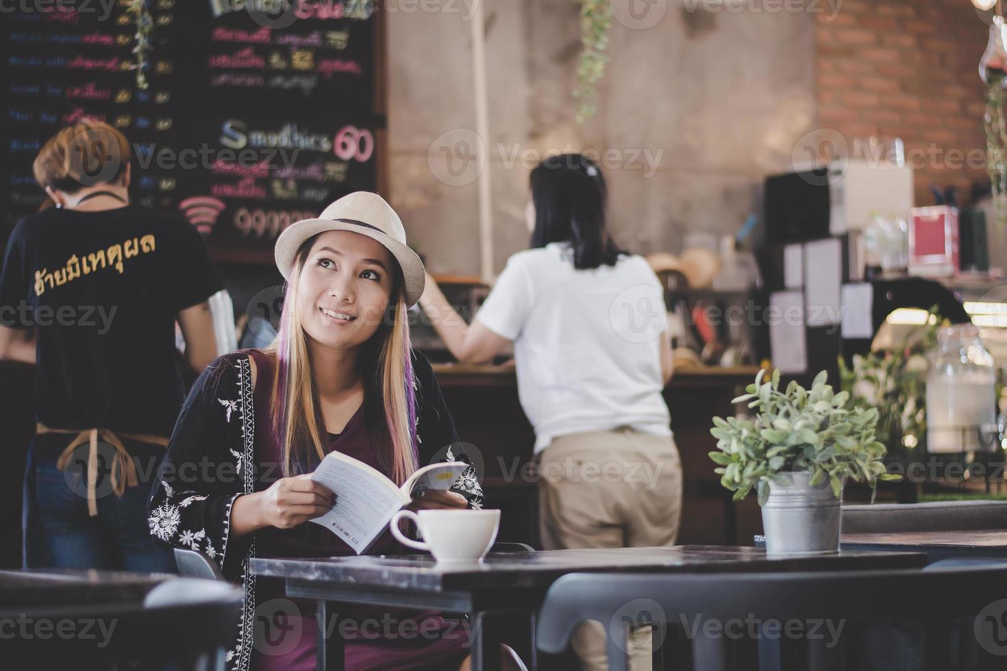 happy business woman lisant un livre tout en vous relaxant au café photo