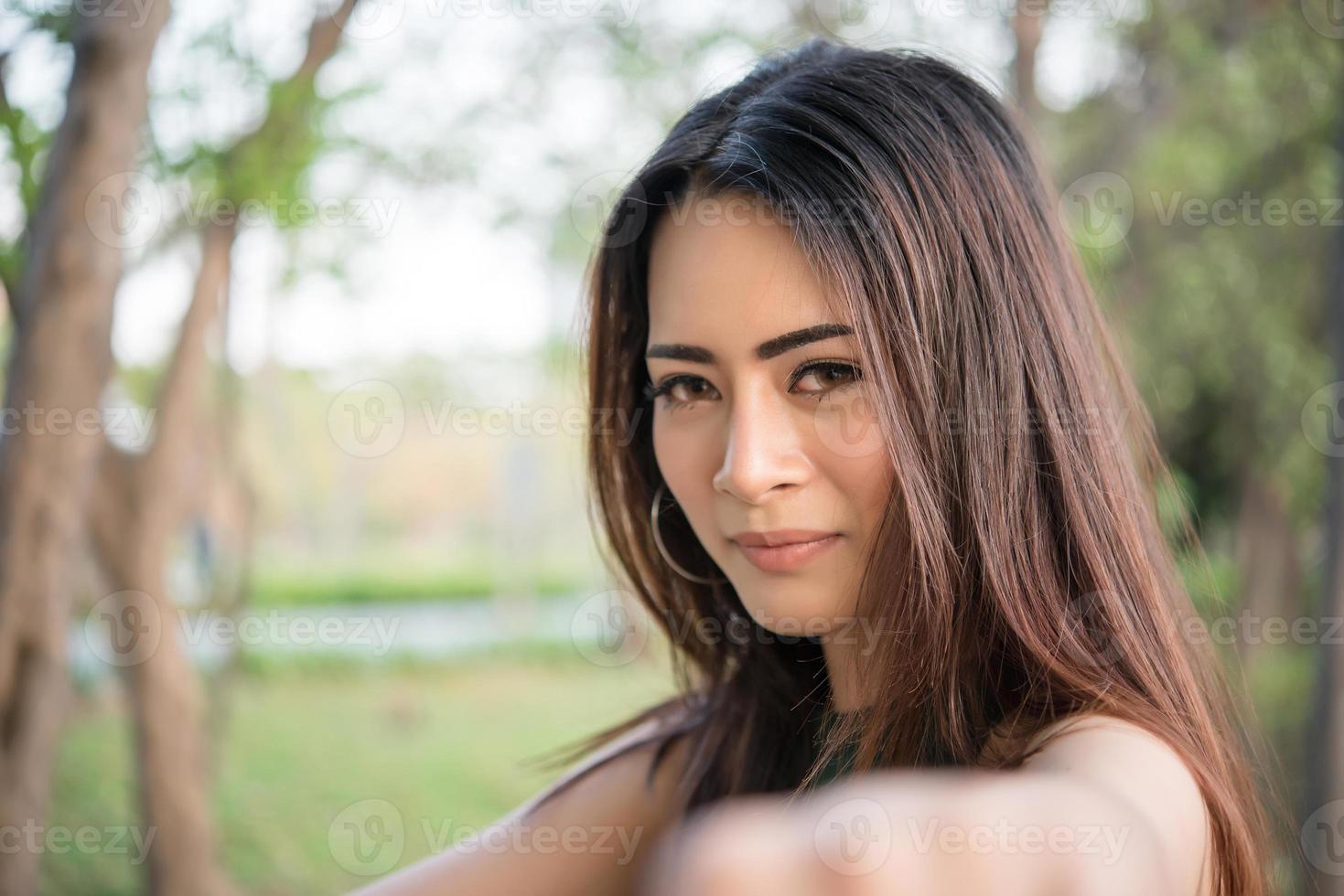 Portrait d'une jeune fille souriante se détendre dans le parc naturel en plein air photo