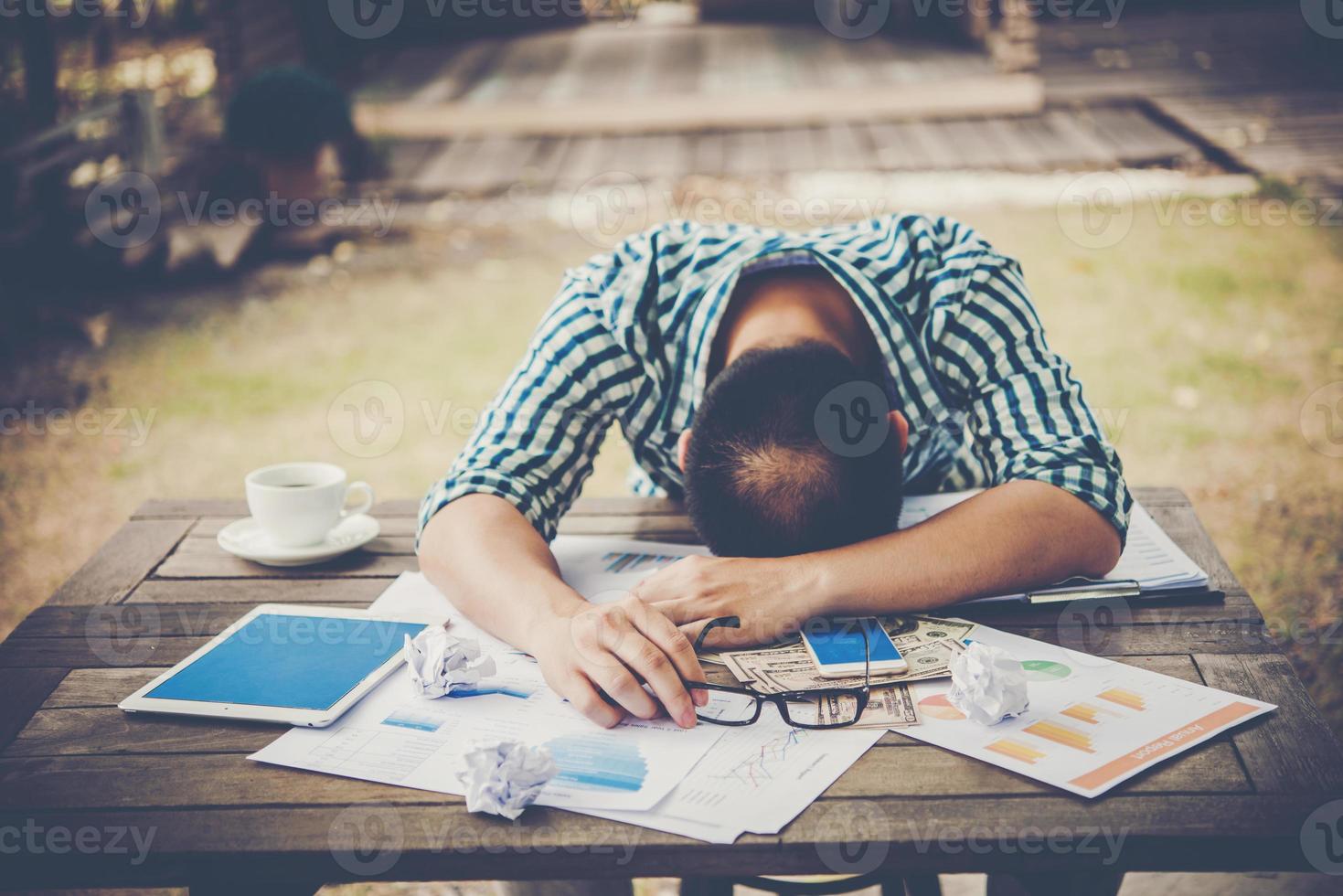 Homme de travail fatigué dormir sur le lieu de travail plein de travail photo