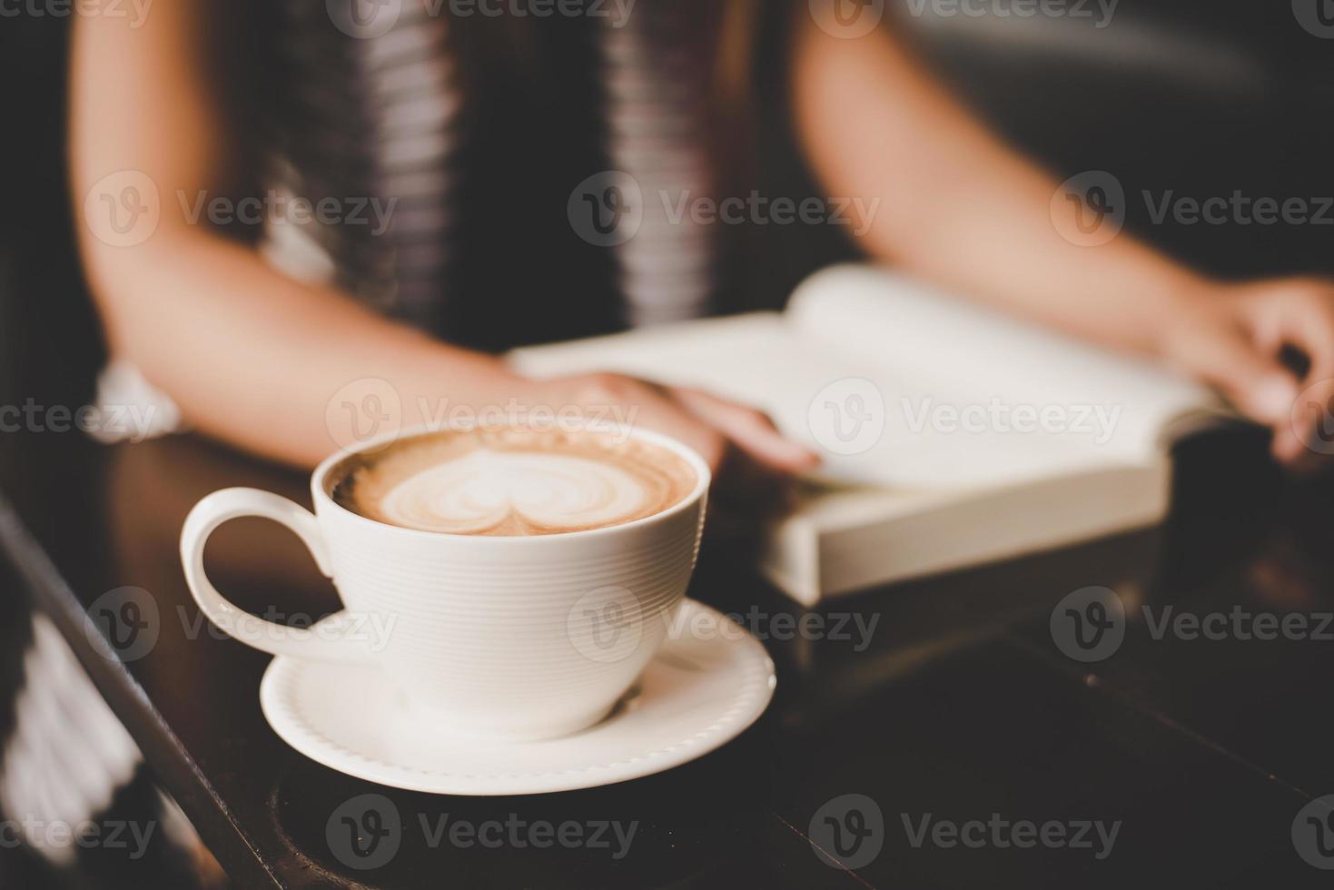 femme asiatique se détendre et lire un livre dans le café photo