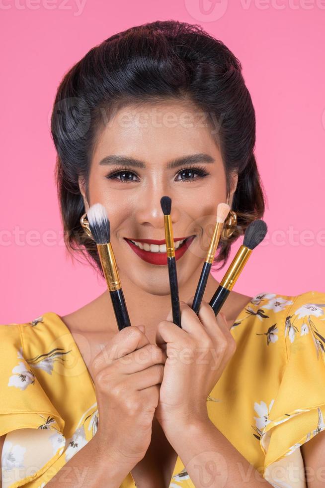 portrait d'une femme avec des pinceaux de maquillage photo