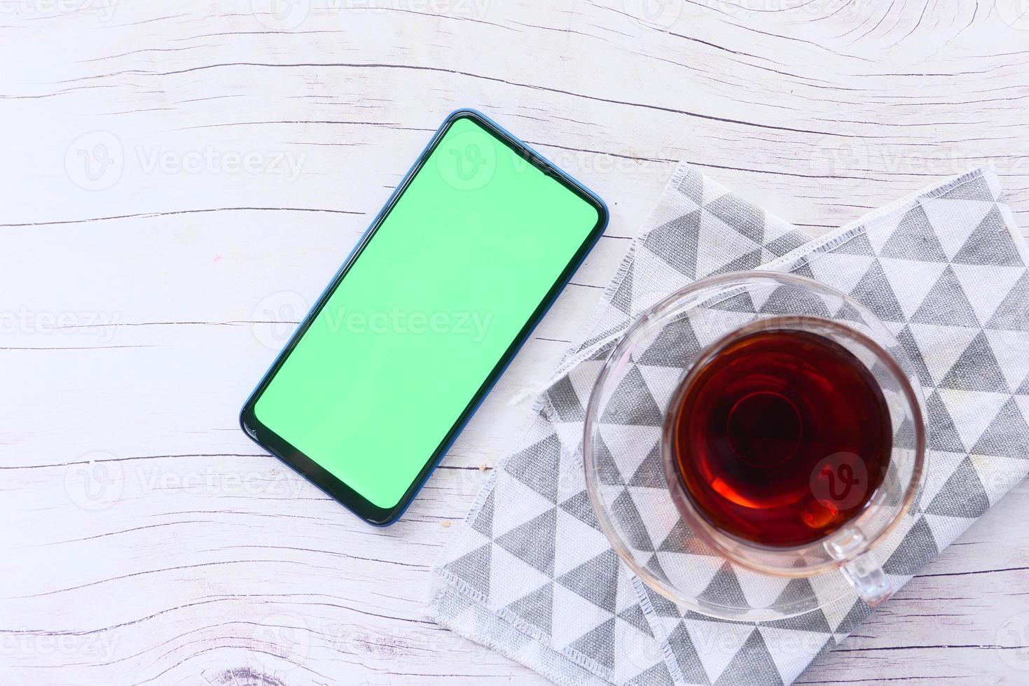 vue de dessus d'un téléphone intelligent et du thé sur la table photo