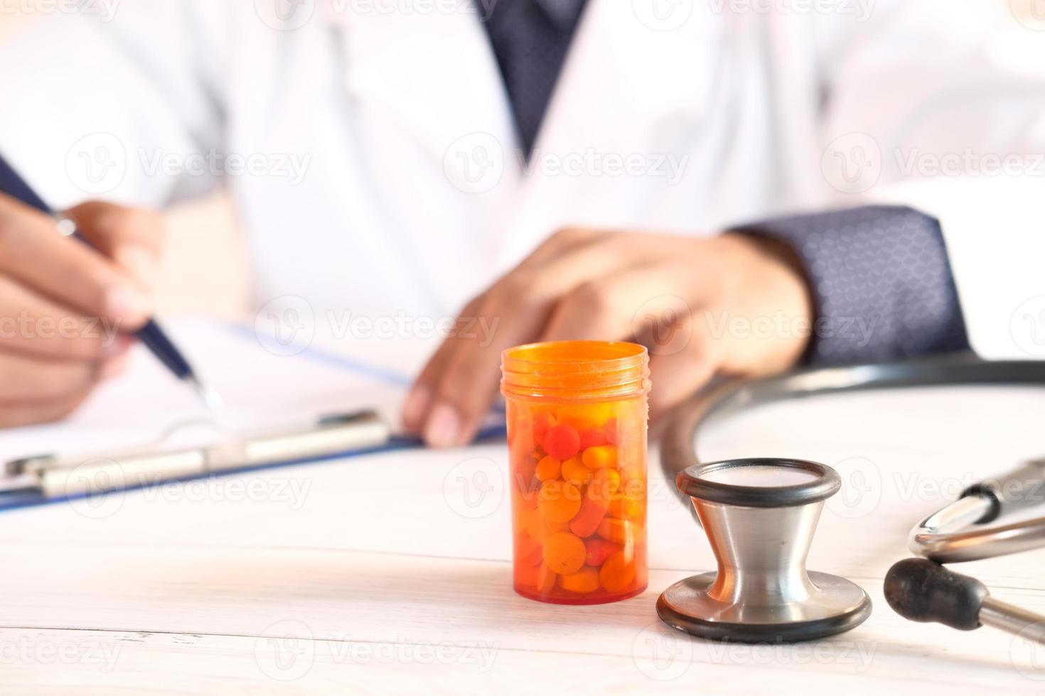 La main du médecin écrit la prescription sur le bureau photo