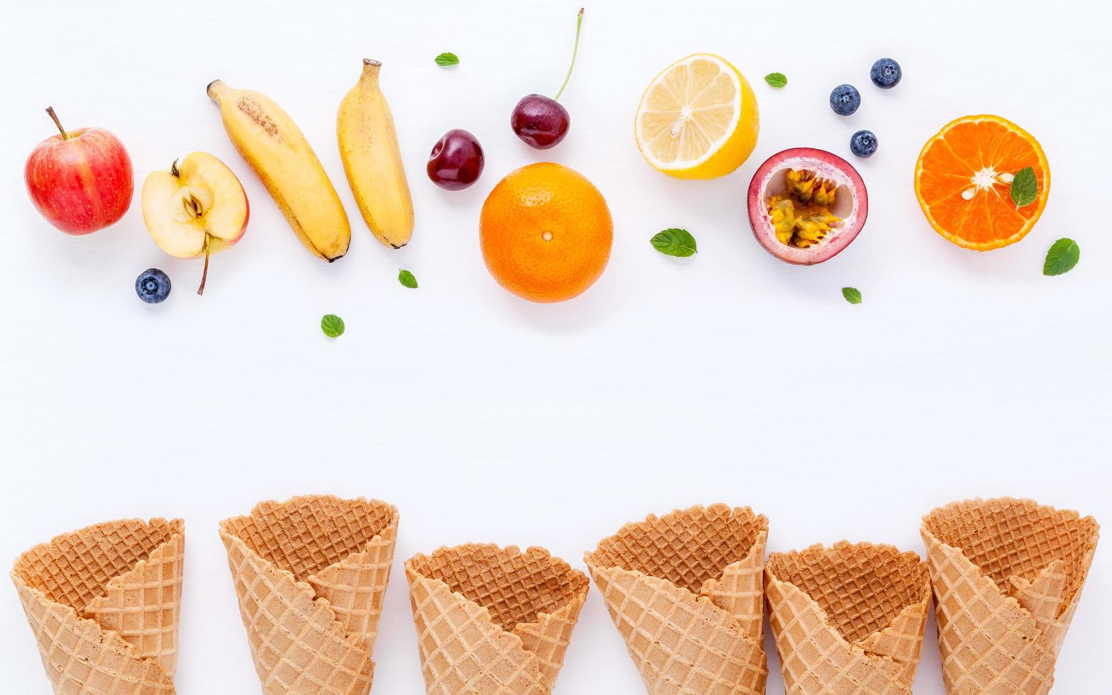 fruits frais et cônes de gaufres sur blanc photo