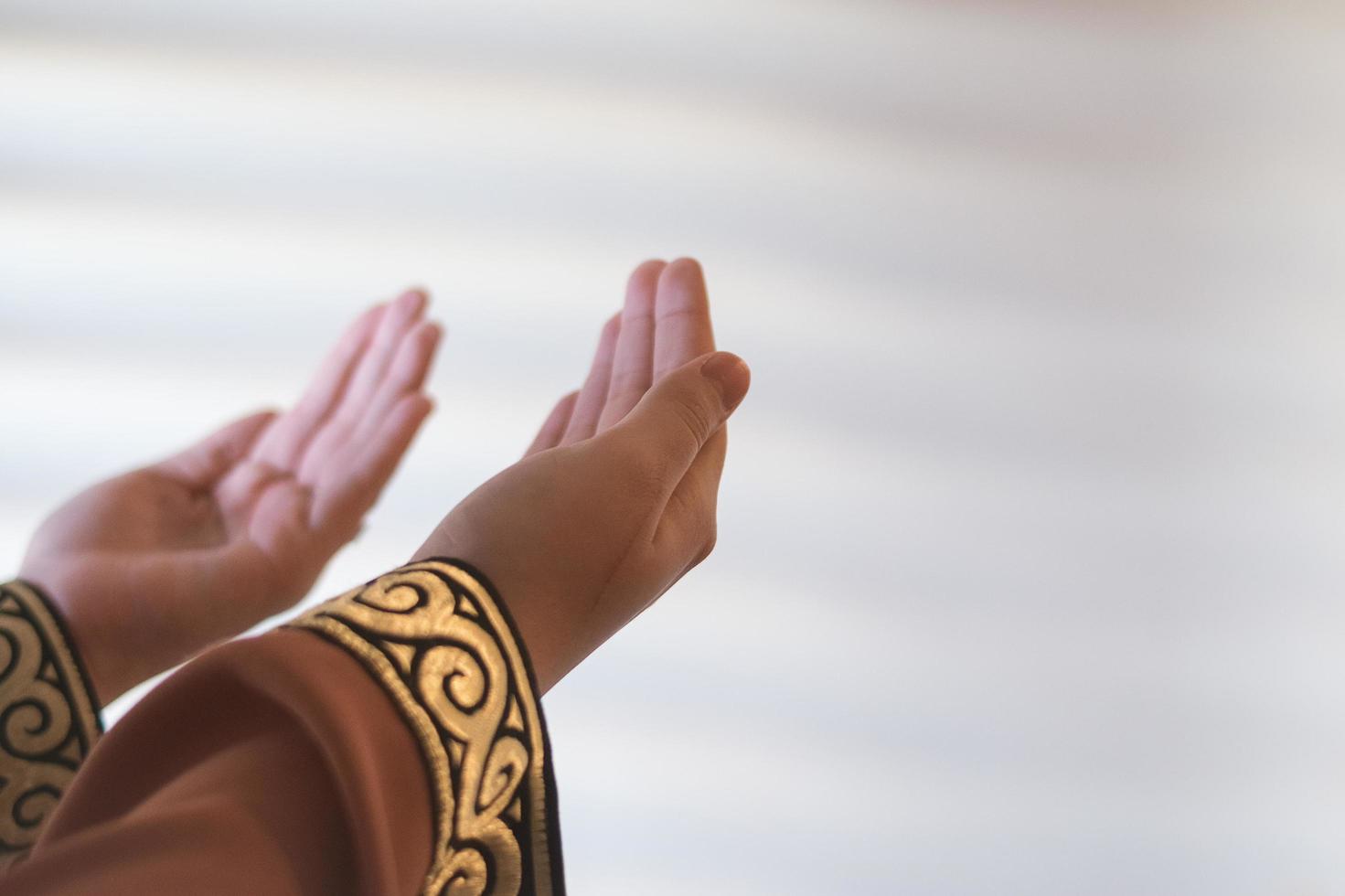 mains d'une femme musulmane ou islamique faisant des gestes tout en priant à la maison photo