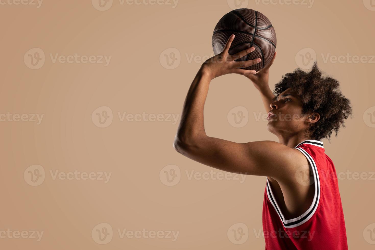 basketball joueur jette le Balle sur marron Contexte. photo