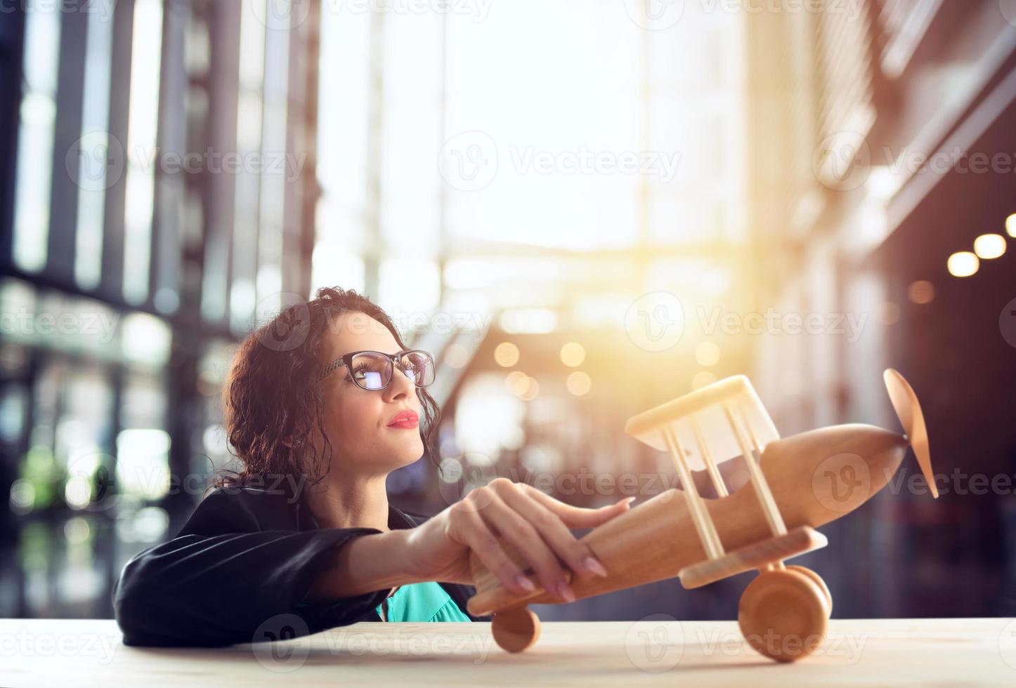 femme d'affaires jouer avec une jouet avion. concept de entreprise Commencez et affaires succès. photo